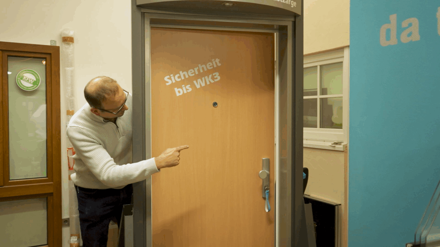 Studio-35 Mann zeigt auf Sicherheitstür mit WK3-Standard, ideal für erhöhten Einbruchschutz.